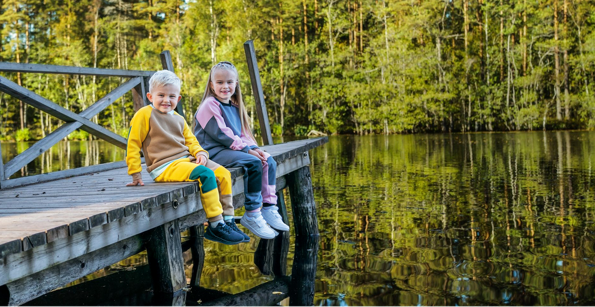 Kaksi lasta Vainion vaatteissa laiturilla